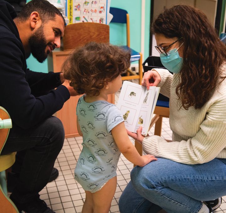 A la PMI, lecture expliquée à un enfant accompagné de son père