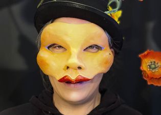 Une comédienne porte le masque du personnage Scrooge