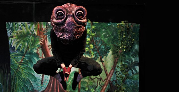 Un acteur portant un masque de crapaud saute