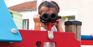 Une petite fille joue sur un jeu dans une cour d'école